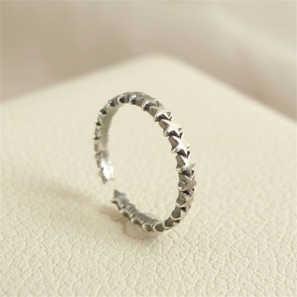 Oxidised linked stars ring, close angle showing star-link texture on silver band