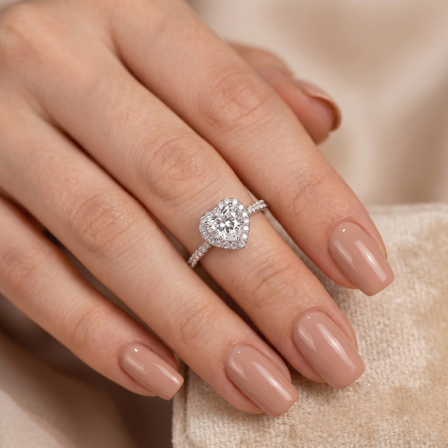 Heart Halo Ring close-up on hand: heart halo around central stone, pavé band