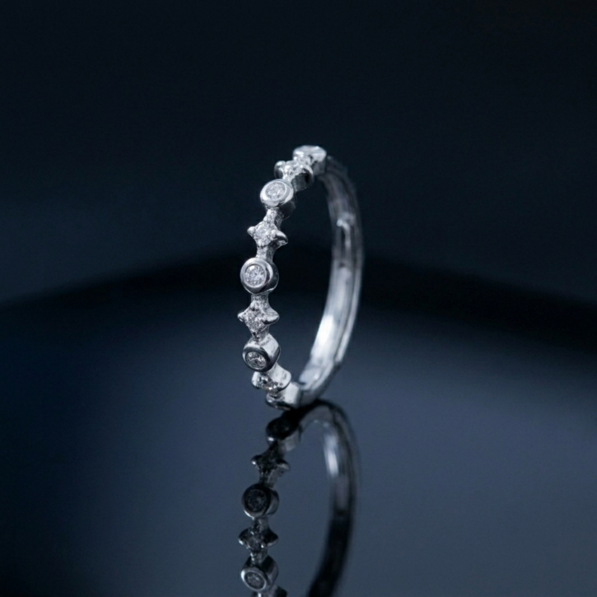 Silver CZ ring with linked star bezels and round stones along the band
