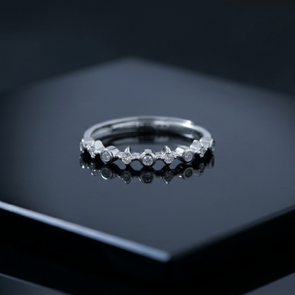 Silver CZ ring with star-shaped bezels and round stones across the band
