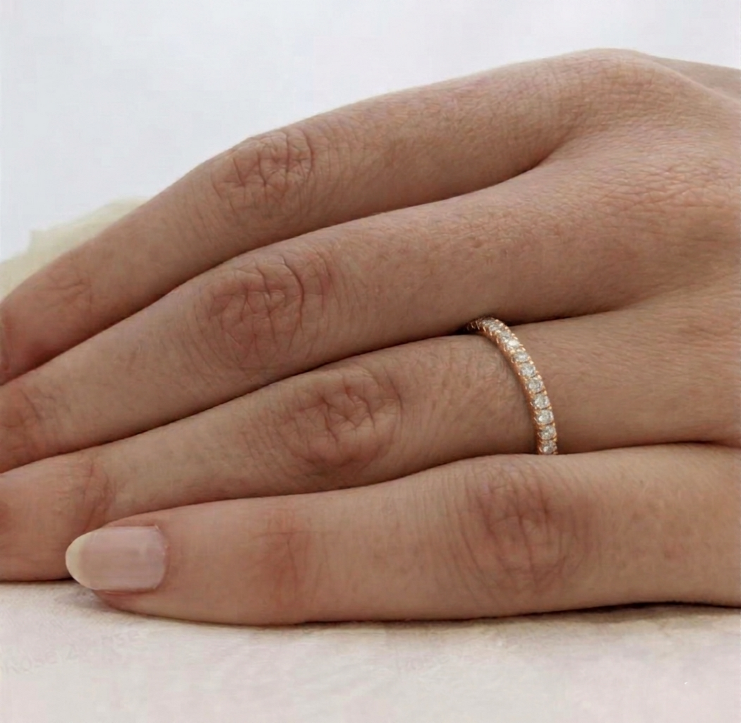 Rose gold CZ stacking eternity band on finger, continuous pavé stone row