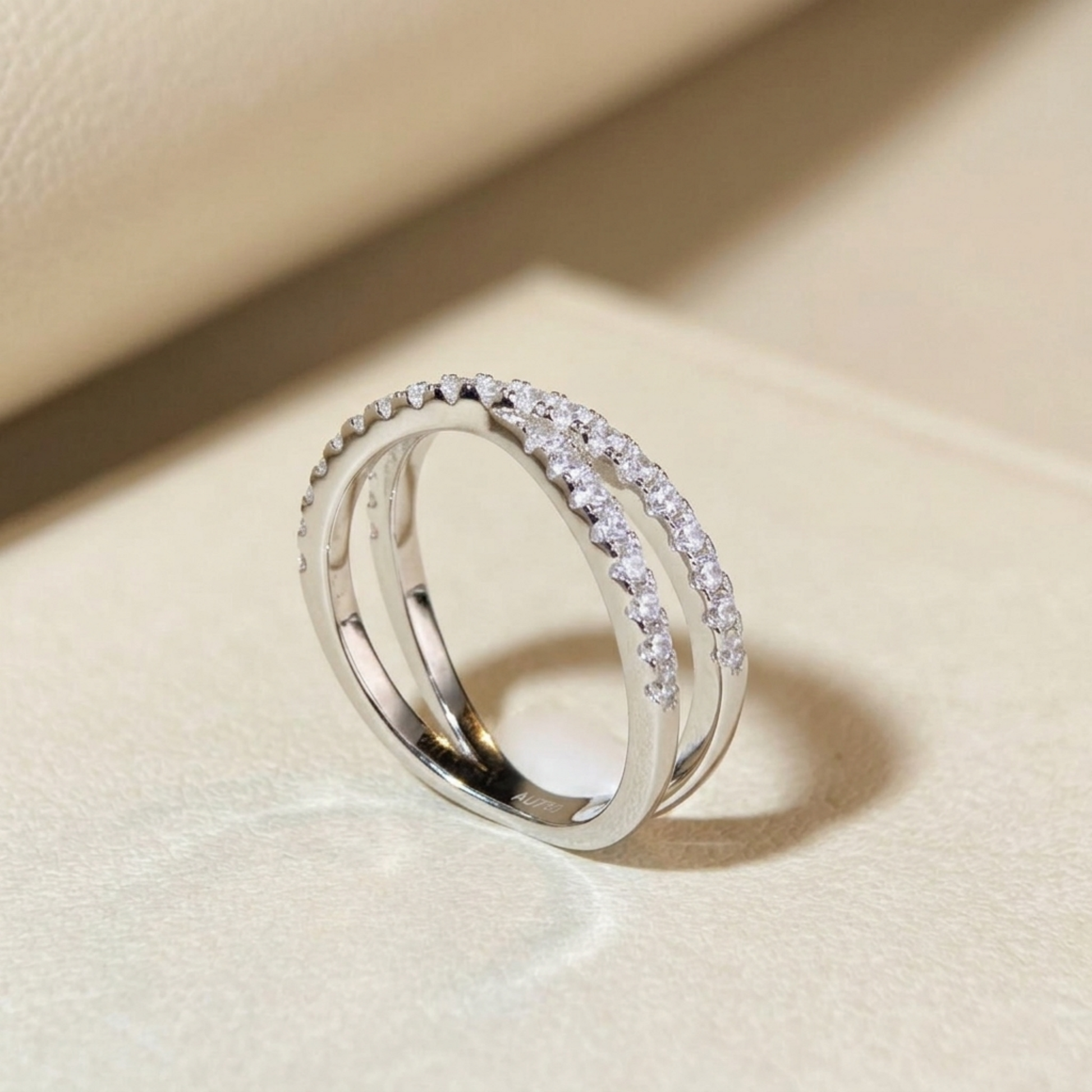 Infinity criss-cross ring side view, silver-tone with pavé stone row detail