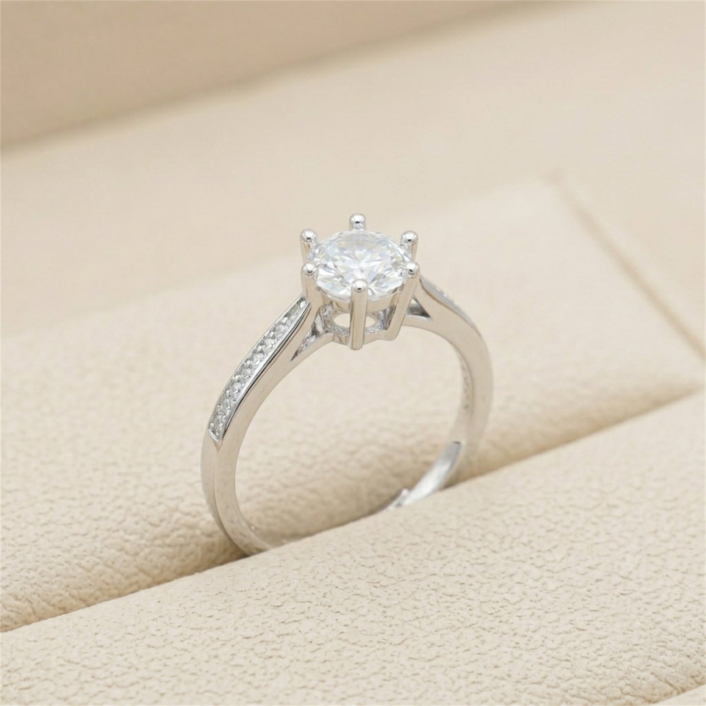 Round solitaire diamond ring with pavé band, silver-tone metal, close side angle