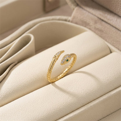 Gold-tone snake wrap ring with green eye and small clear stones