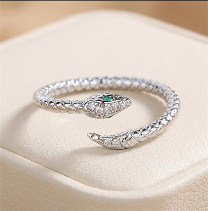 Silver-tone snake wrap ring with green eye, oval center, clear stones
