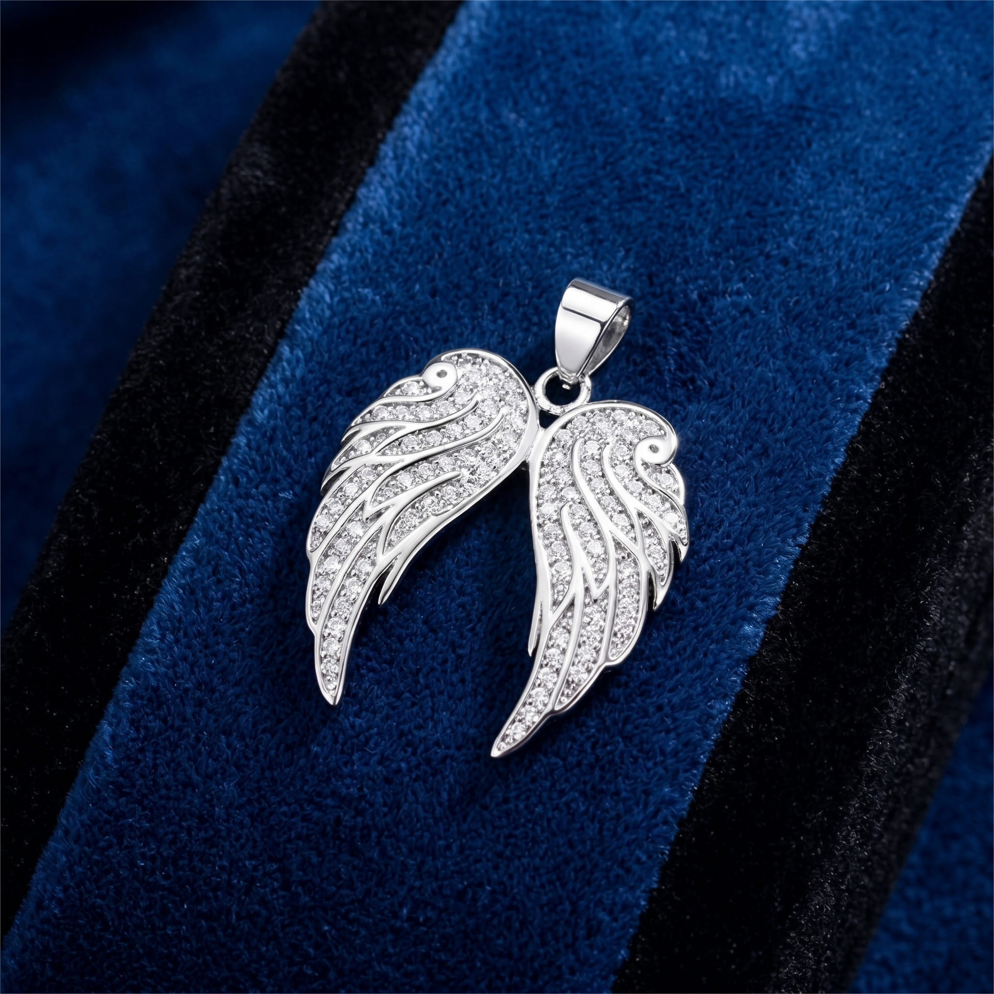 Two-wing angel pendant set with pavé stones and a top loop bail
